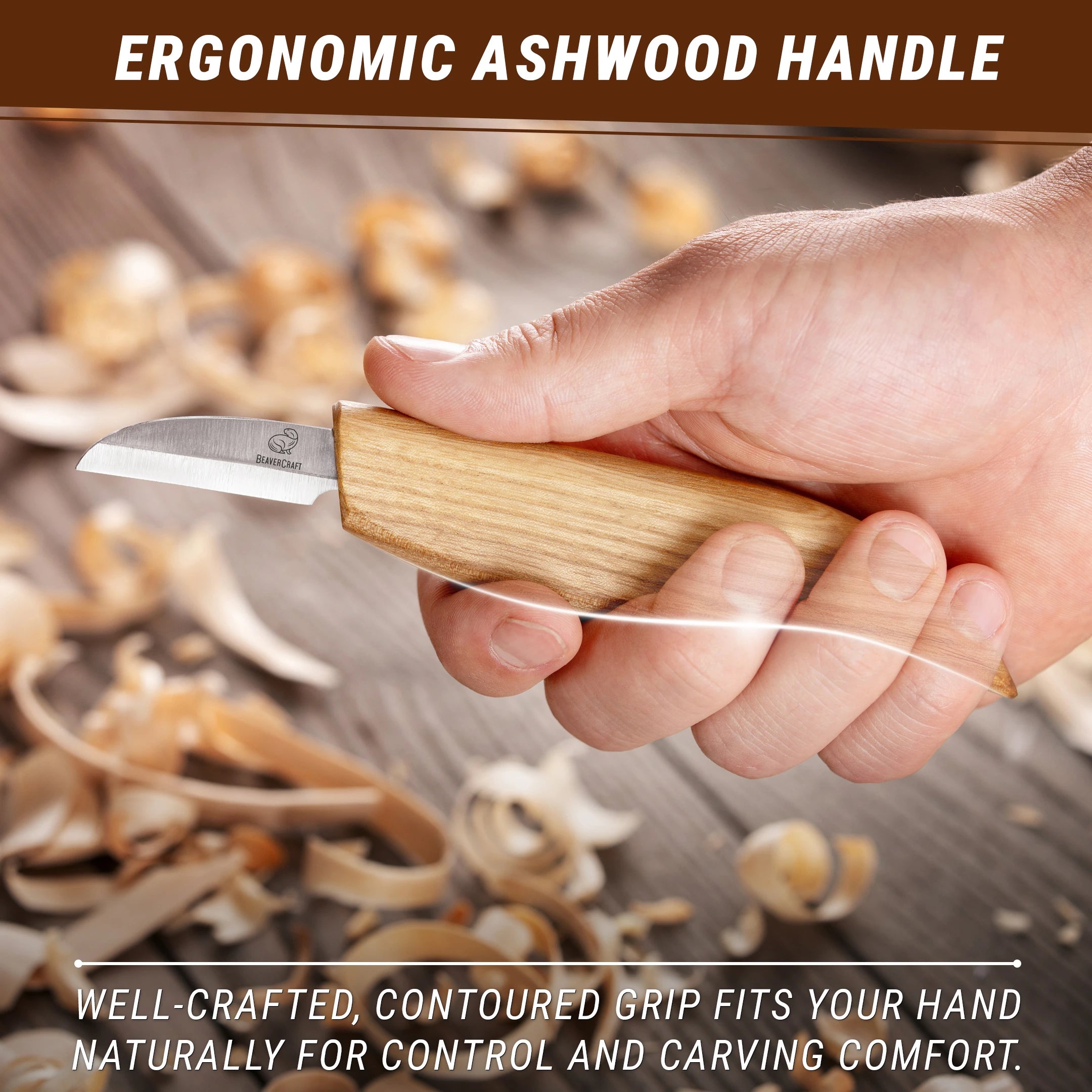 Hand holding a knife with an ergonomic ashwood handle, surrounded by wood shavings.