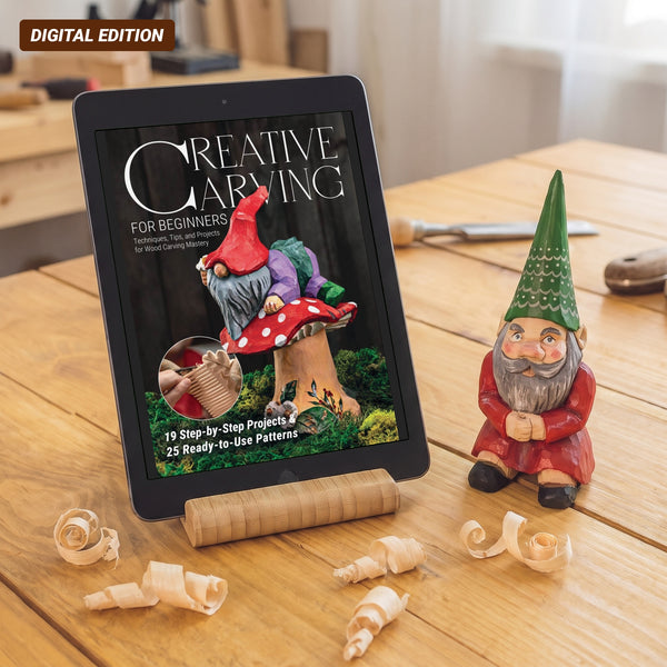 Creative Carving for Beginners digital magazine cover on a tablet next to a carved garden gnome on a workbench