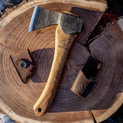 The AX1 hatchet on a stump with its edge cover and belt loop