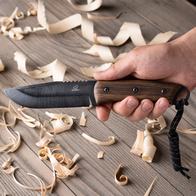 The BSH4 knife in hand over wood shavings